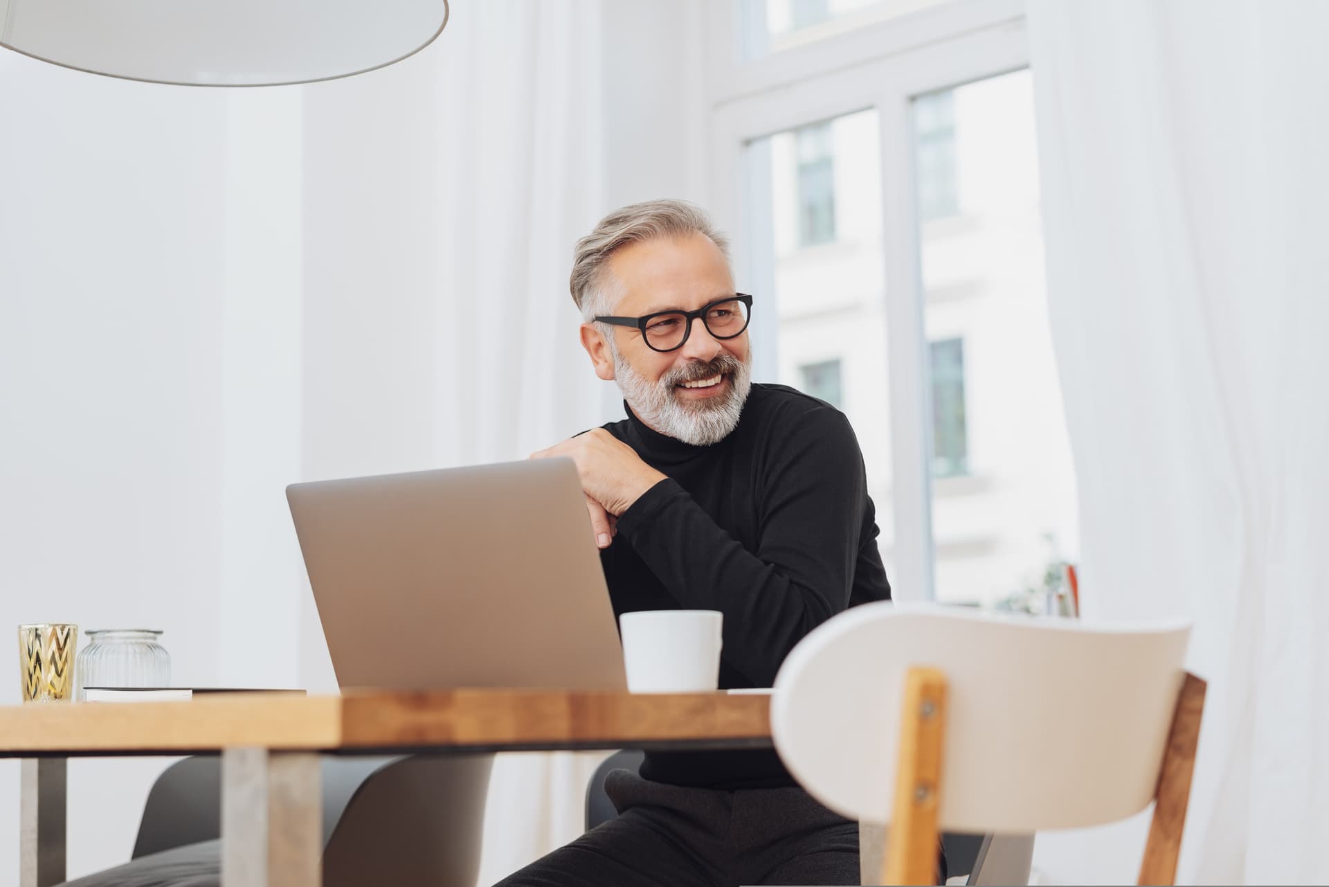 Mann lächelt am Laptop