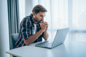 Mann vor dem Laptop macht sich Sorgen wegen Inkassomahnungen