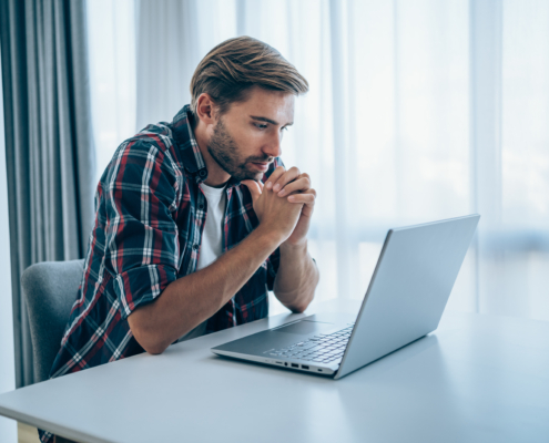 Mann vor dem Laptop macht sich Sorgen wegen Inkassomahnungen